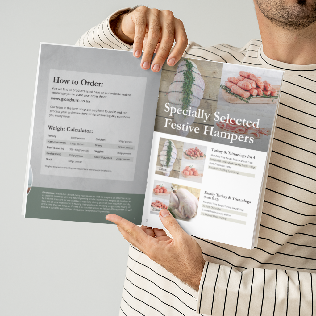 A person in a beige and white striped shirt holds open a printed brochure or order guide about festive hampers. The brochure pages show text such as 'How to Order' and 'Specially Selected Festive Hampers' with photos of meat products, set against a plain light gray background.