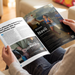 A person holding open a printed magazine or brochure using 100% recycled paper stocks.